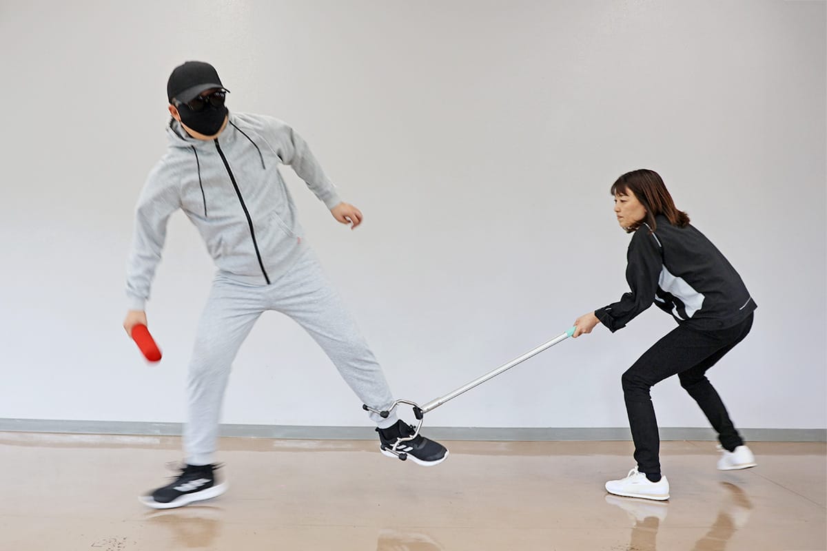 弁慶SB224で不審者の脚をなぎ払し体勢を崩す様子